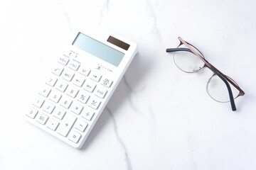 白いテーブルの上の、白い電卓
