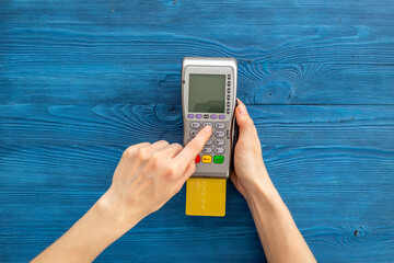 Female holding in hands bank terminal for contactless payment by credit cards. Banking and shopping concept
