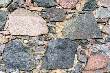 
a stone wall made of stones of different colors and shapes.