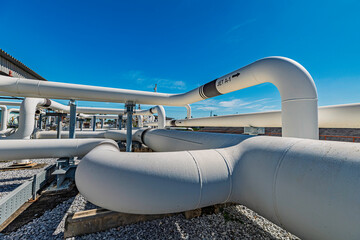 Male worker inspection at steel long pipes and pipe elbow in station oil factory during refinery...