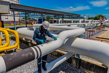 Male worker inspection and measurement thickness pipeline oil and gas at check record pipeline