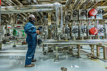 Male work inspection process stainless steel tanks and pipe with pressure meter in equipment tank...