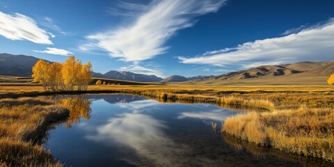 Obraz premium Stunning autumn landscape with vibrant trees reflecting in tranquil water under a clear blue sky