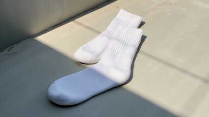 Running socks, White running socks on gray concrete minimalist setup sunlight streaming diagonally clean composition
