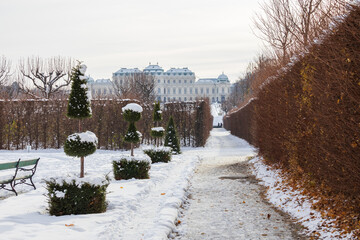 A serene winter scene capturing the baroque architecture of Vienna's Belvedere Palace, framed by...