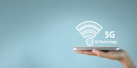 Smartphone in hand with glowing 5G technology icon representing fast internet,mobile connectivity,futuristic communication,digital business, online services,cloud computing, artificial intelligence.