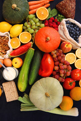 Various healthy fruits, vegetables and cereals on dark background. Top view.