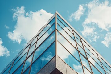 The facade of a modern building with blue windows stands out against a cloudy sky