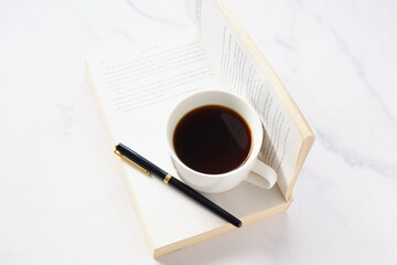 コーヒーを飲みながら、のんびりペーパーバック（洋書）を読んでいるイメージ
