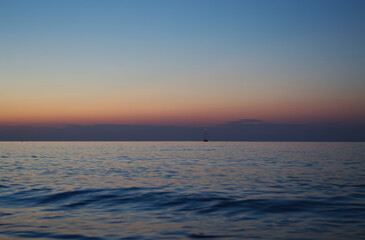 big waves at sunset, beautiful high waves at the beach, view at sea, sunset at the sea in Italy, grey clouds, blue and purple colors, foaming goutweed, purple sky, pink and blue sky	