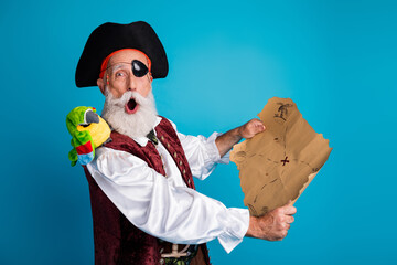 Photo portrait of senior funny pirate grandpa shocked hold treasure map wear masquerade party...