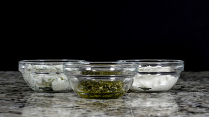Three glass bowls filled with different sauces