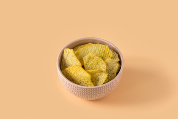 Potatoes Chips. Top view of an isolated  porcelain bowl with a pile of fluted potato chips with...