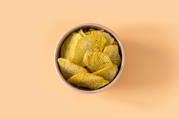 Potatoes Chips. Top view of an isolated  porcelain bowl with a pile of fluted potato chips with...