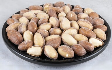 Obraz premium Roasted Almonds in Black Bowl Close Up Photo