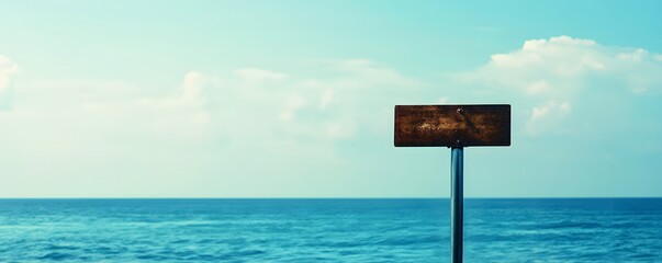 Blank wooden sign stands prominently against a serene ocean backdrop