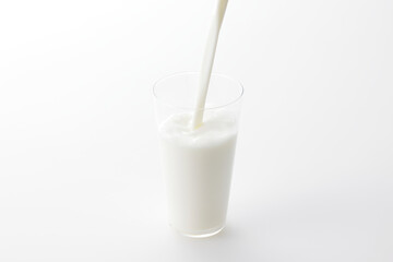 白い背景とグラスに注いだ牛乳　Milk poured into a glass with a white background