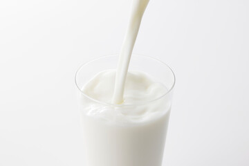 白い背景とグラスに注いだ牛乳　Milk poured into a glass with a white background