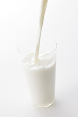 白い背景とグラスに注いだ牛乳　Milk poured into a glass with a white background