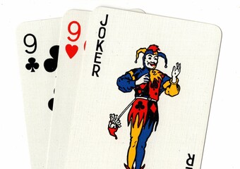 A hand of playing cards featuring a joker.