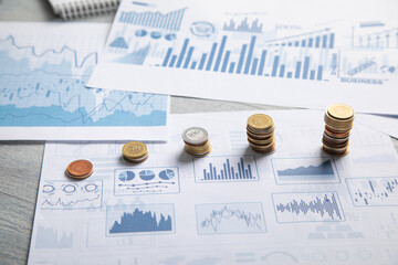 Stack of coins with a financial growth graphs.