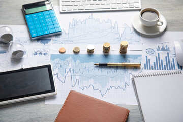 Stack of coins with a financial growth graphs.