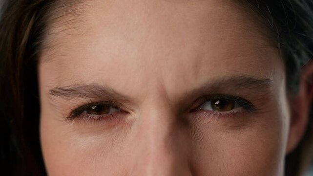 Extreme close-up view female dark human eyes Caucasian woman girl gaze staring looking front strong eyesight eye vision sight skin wrinkles angry annoyed student businesswoman health medical problem