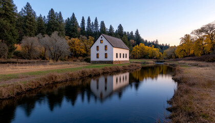Fototapeta premium Tranquil river valley views. serene river valley features historic stone mill surrounded by autumn trees