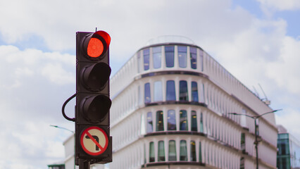 Traffic lights in a major city with high rise buildings and busy streets.