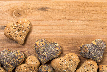 Rustic background with heart shaped buns border on wooden planks