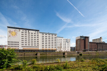 Decaying industrial architecture of a former flour mill at Deutzer Hafen, Cologne. Massive stone buildings with crumbling facades, old railway tracks, and graffiti-covered walls
