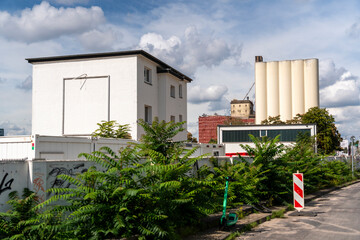 Decaying industrial architecture of a former flour mill at Deutzer Hafen, Cologne. Massive stone buildings with crumbling facades, old railway tracks, and graffiti-covered walls