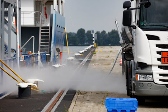 Tank truck delivers LNG gas to ship in a Dutch harbor during operational activity
