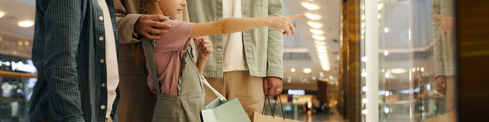 Website banner with unrecognizable family standing in front of storefront in shopping mall