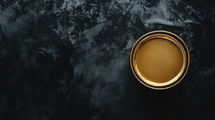 Golden paint can on dark textured surface