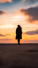 woman long coat beach sunset