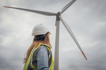 An engineer keenly observing the ongoing wind turbine installation process at a renewable energy...