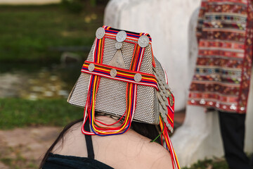 Back view female ethnic hilltribe wearing handmade embroidery Akha colorful headdress