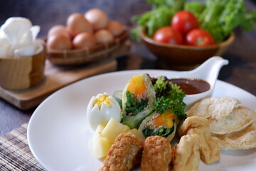 Gado-gado is a food consisting of vegetables, potatoes, tempeh, tofu, boiled eggs, etc. seasoned with peanut sauce and so on 2