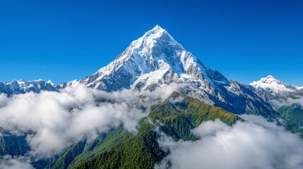 Obraz premium Stunning Snow-Capped Mountain Peak Surrounded by Clouds and Greenery