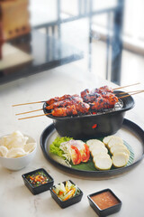 Skewered grilled chicken satay served with fresh vegetables