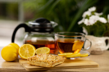 Glass cup of tea, teapot, sliced lemons on the table. Kettle with tea. Lemon tea