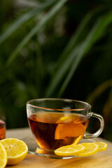 Glass cup of tea, teapot, sliced lemons on the table. Kettle with tea. Lemon tea