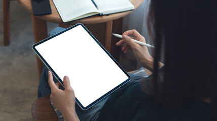 Mockup image of woman using digital tablet with blank white screen during working with laptop computer at coffee shop, close up. Mockup tablet for online marketing or web template