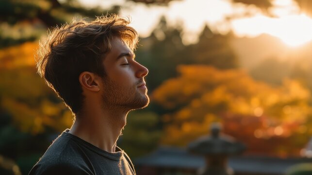 Man Practicing Deep Breathing Exercises Outdoors Amidst Nature in a Scenic Park with Warm Sunset Light