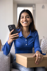 Portrait of happy e-commerce client enjoy received parcel box hold smartphone, write positive...