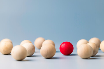 Unique red ball in the grouo of wooden red balls, being different concept, noticable in the crowd