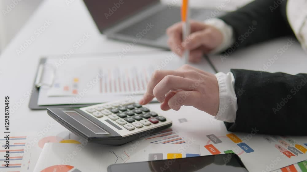 Poster this is an office workspace which features a calculator alongside various financial documents, impor