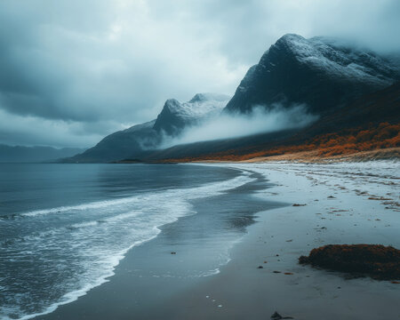 Coastal serenity: Waves meet misty mountains in this tranquil beach scene. A serene landscape of mountains and ocean.