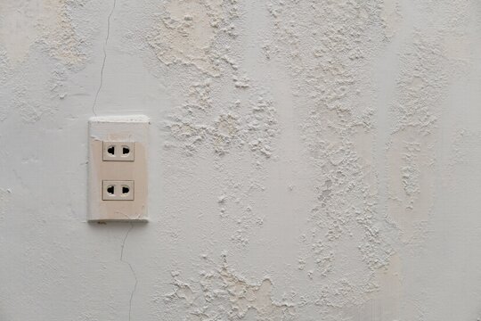 electric plugs with old white wall with mold texture background. messy wall stucco texture